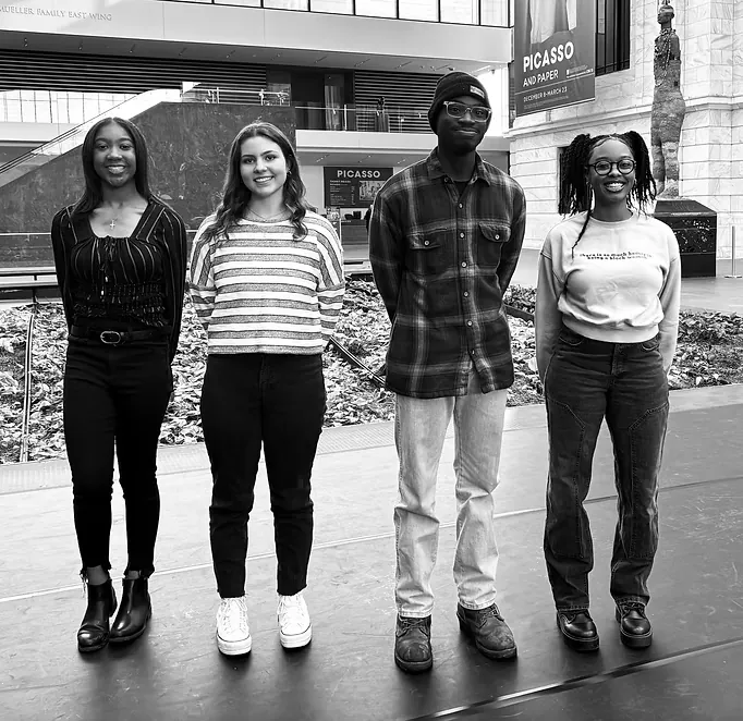 Four young people standing together in the atrium of the Cleveland Museum of Art.